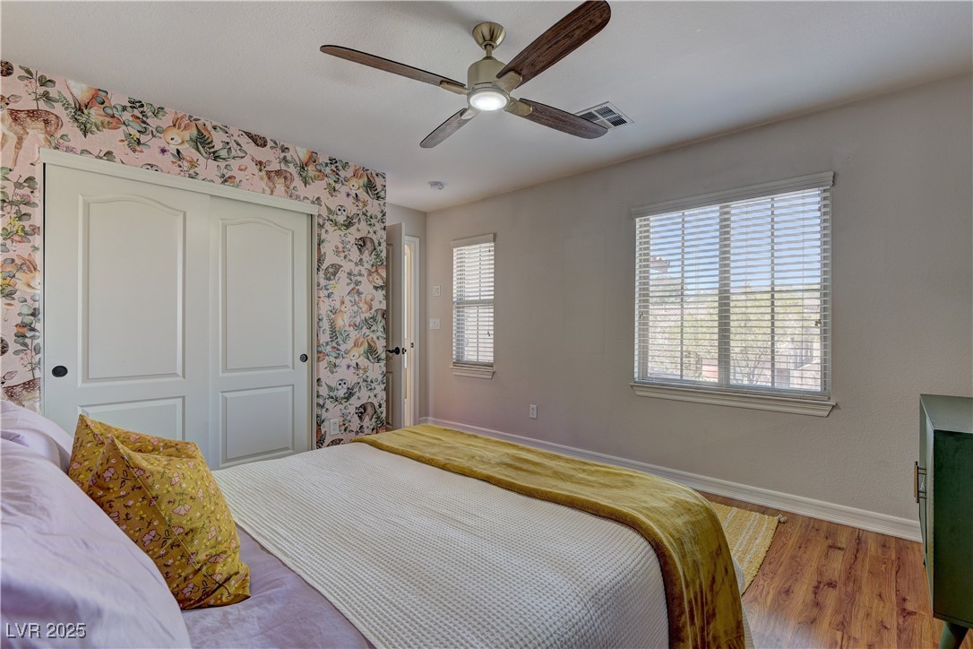 9992 South Sky Parlor Road Las Vegas, NV 89178 - Photo 31 of 42 Bedroom with a closet, light wood-type flooring, baseboards, wallpapered walls, and visible vents