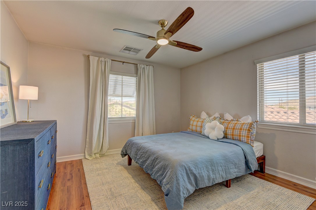 9992 South Sky Parlor Road Las Vegas, NV 89178 - Photo 32 of 42 Bedroom featuring ceiling fan, visible vents, baseboards, and wood finished floors