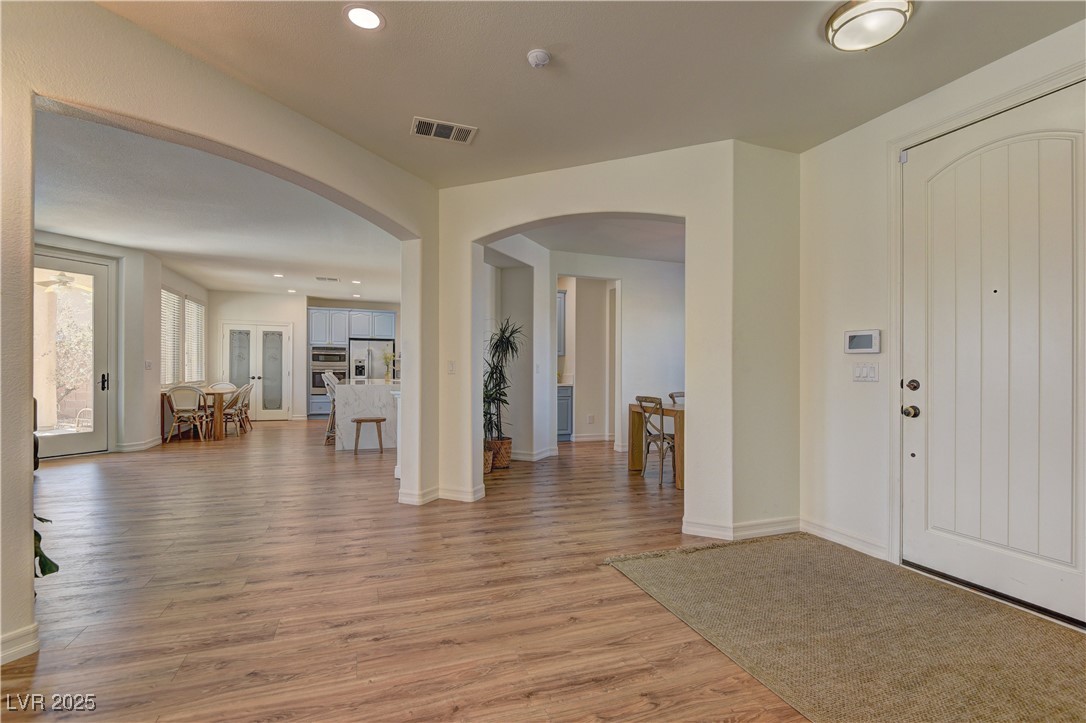 9992 South Sky Parlor Road Las Vegas, NV 89178 - Photo 4 of 42 Foyer featuring visible vents, light wood-type flooring, arched walkways, and recessed lighting