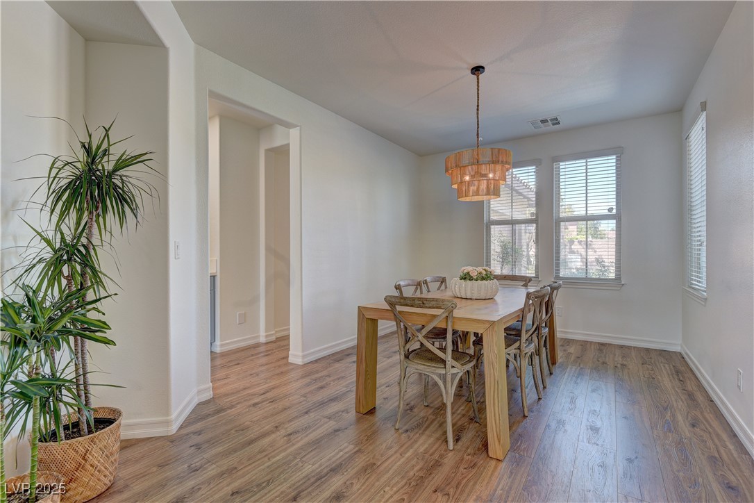 9992 South Sky Parlor Road Las Vegas, NV 89178 - Photo 5 of 42 Dining room featuring light wood-style floors, visible vents, baseboards, and an inviting chandelier