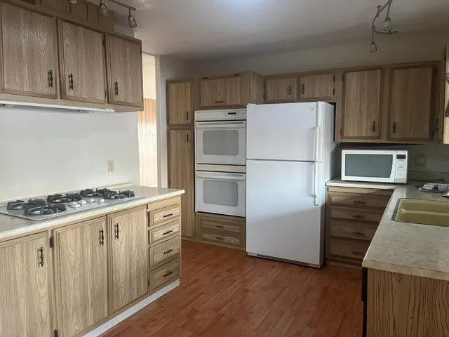a kitchen with wooden cabinets and stainless steel appliances