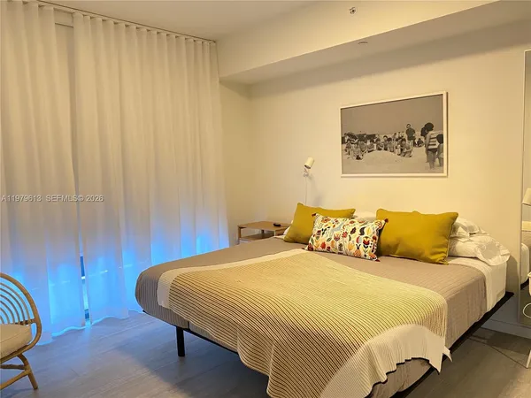 a bed sitting in a bedroom next to a curtain