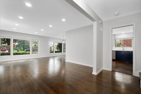 an empty room with wooden floor and a window