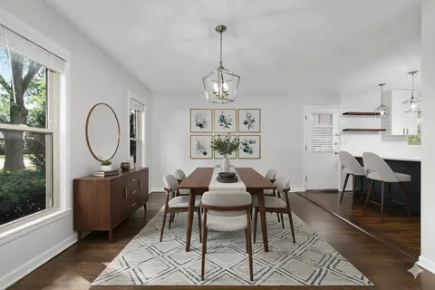 a dining room with furniture a chandelier and wooden floor