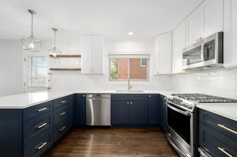 a kitchen with stainless steel appliances granite countertop a refrigerator and a wooden floor
