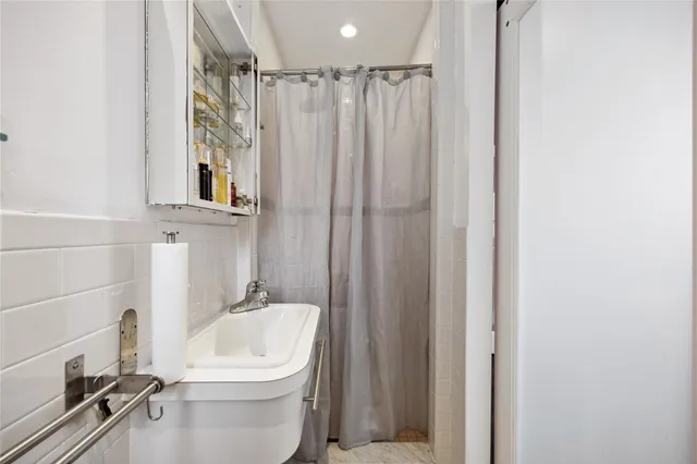 a bathroom with a sink a toilet and shower curtain