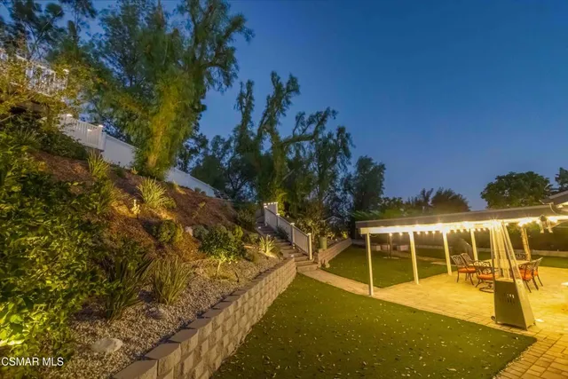 a backyard of a house with table and chairs