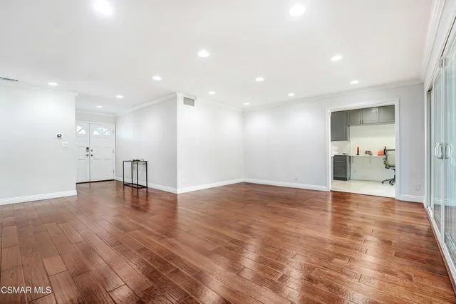 a view of empty room with wooden floor