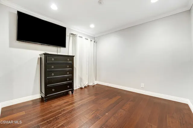 a view of room with wooden floor and flat screen tv