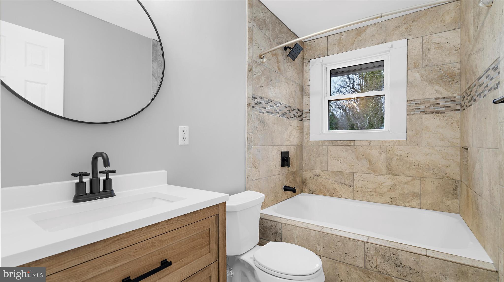 8009 Nolcrest Road Glen Burnie, MD 21061 - Photo 15 of 35 a bathroom with a sink a toilet and a bathtub