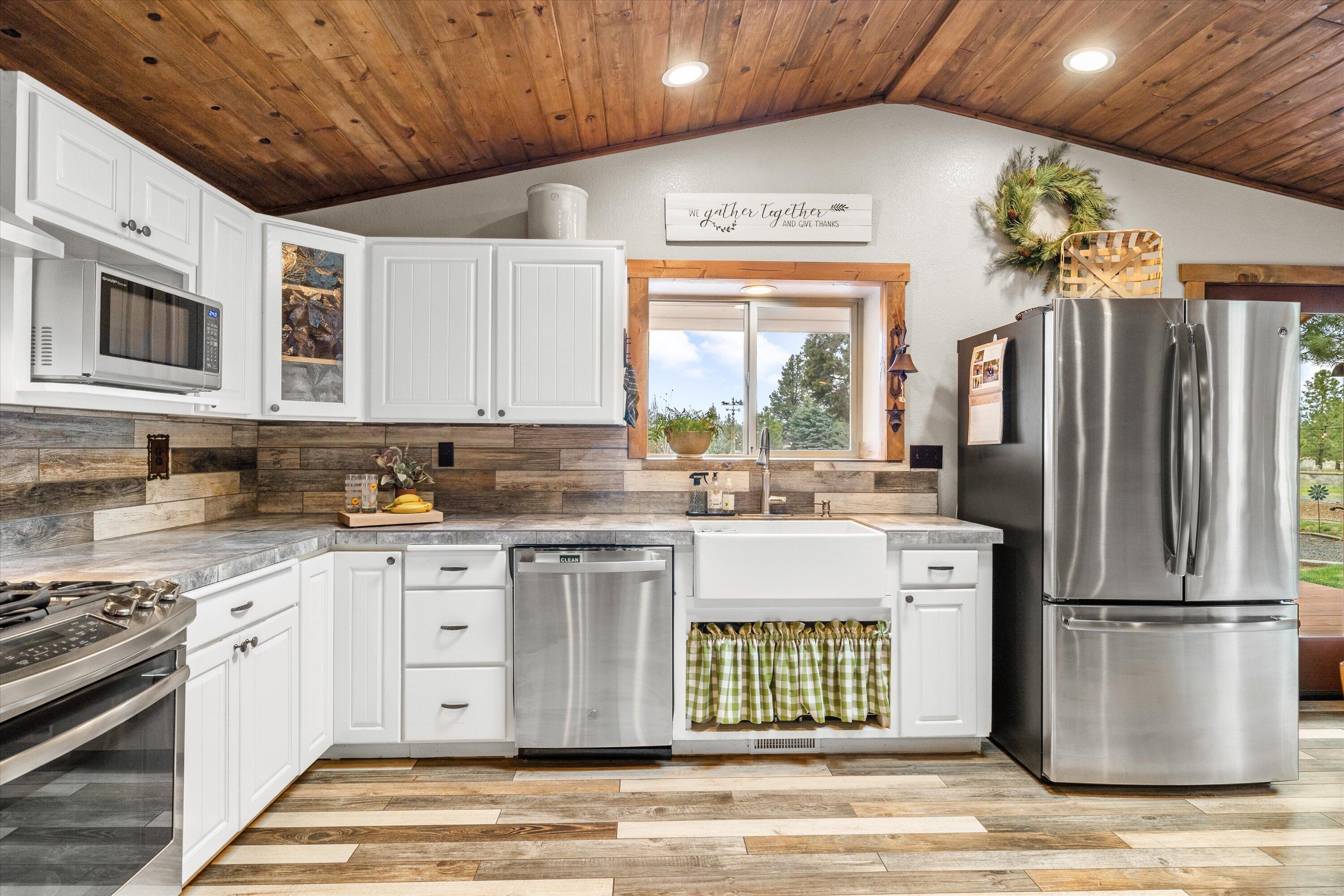 15868 Lundy Road Sisters, OR 97759 - Photo 13 of 53 a kitchen with stainless steel appliances granite countertop a refrigerator a stove a sink dishwasher and wooden cabinets with wooden floor