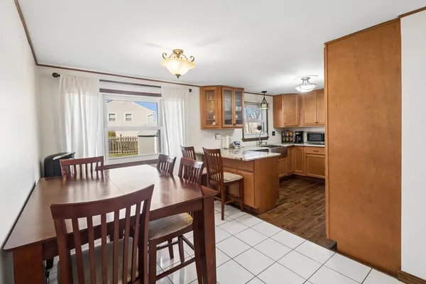 a kitchen with a dining table chairs and a refrigerator