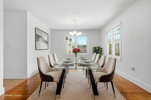 a dining room with furniture potted plants and wooden floor