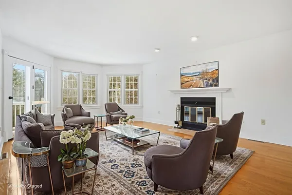 an empty room with chandelier fan and windows