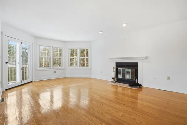 a view of an empty room with a fireplace and a window