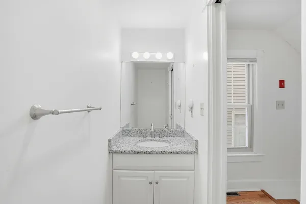 a bathroom with a granite countertop sink and a mirror