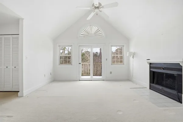 an empty room with windows and fireplace