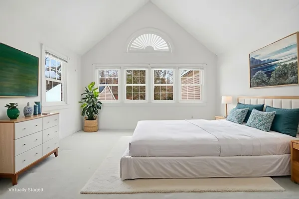 a bedroom with a large bed and windows