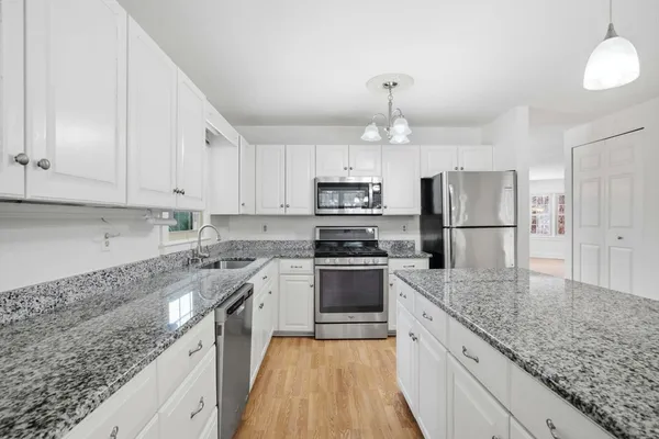 a large kitchen with cabinets stainless steel appliances and a counter top space