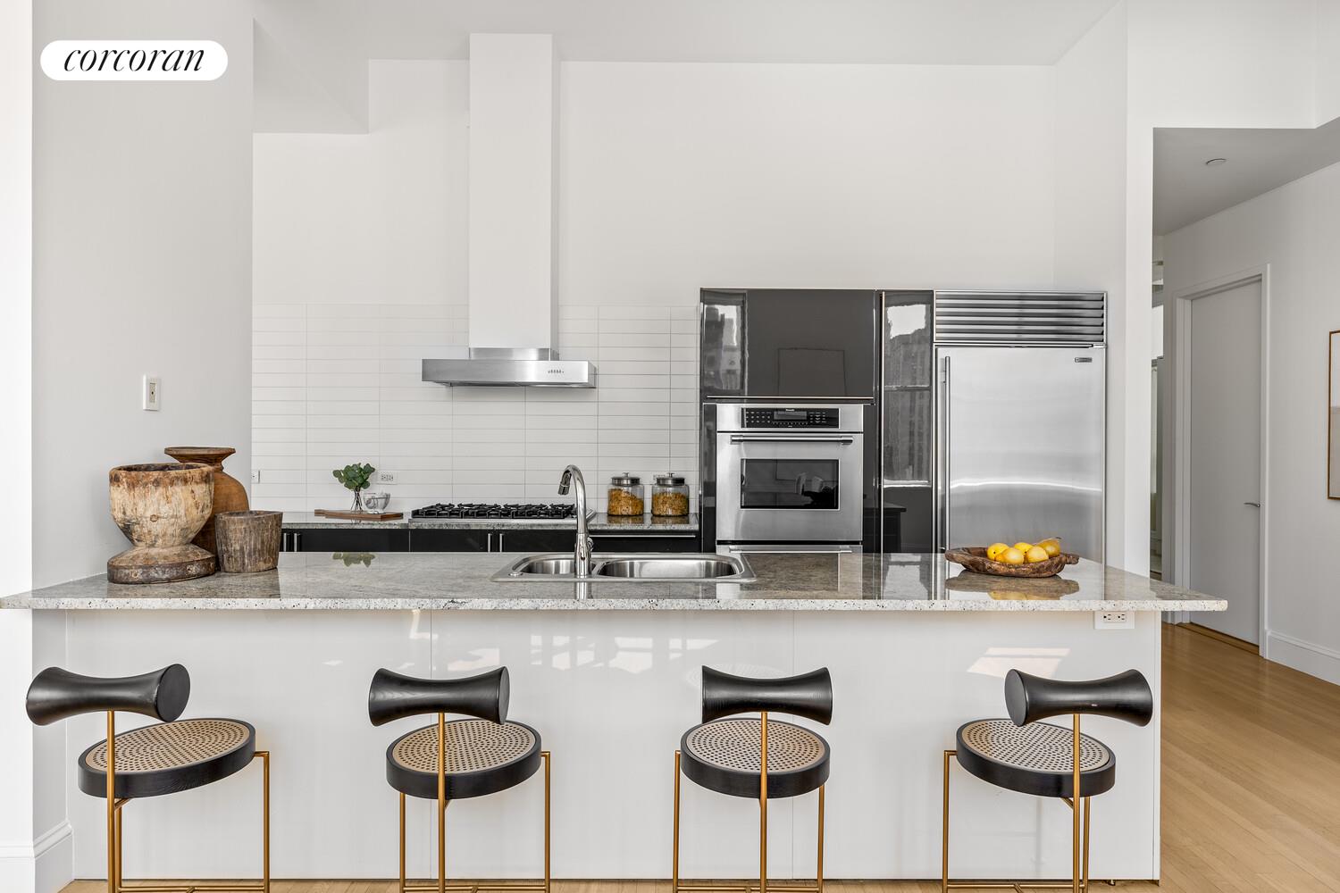 129 Lafayette Street, Unit 8C Manhattan, NY 10013 - Photo 3 of 11 a kitchen with stainless steel appliances granite countertop a sink and a refrigerator
