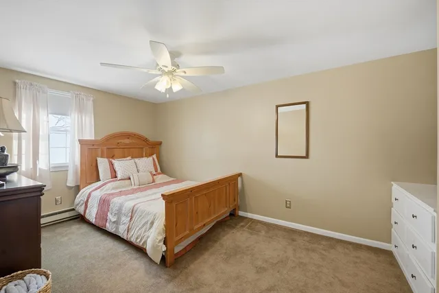 a bedroom with a bed chandelier and a window