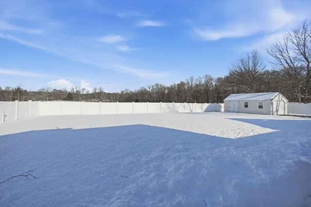 a view of a house with a yard and wooden fence