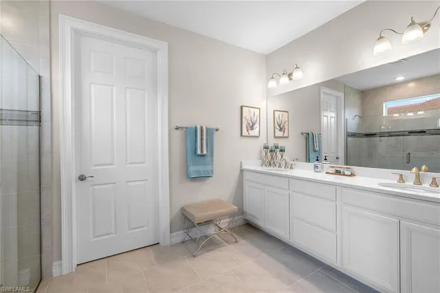 a spacious bathroom with a double vanity sink a mirror and a bathtub