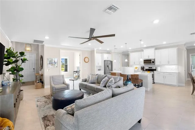 a living room with furniture kitchen view and a potted plant