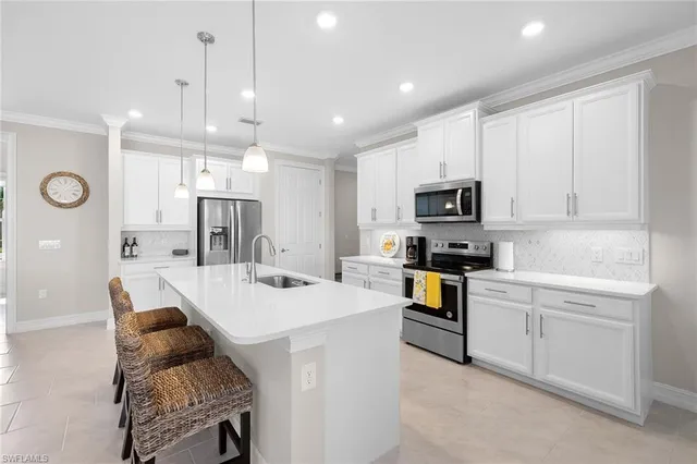 a kitchen with a refrigerator a stove top oven a sink dishwasher and white cabinets with wooden floor