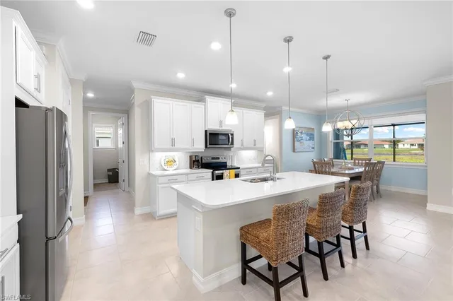 a kitchen with a dining table chairs refrigerator and microwave