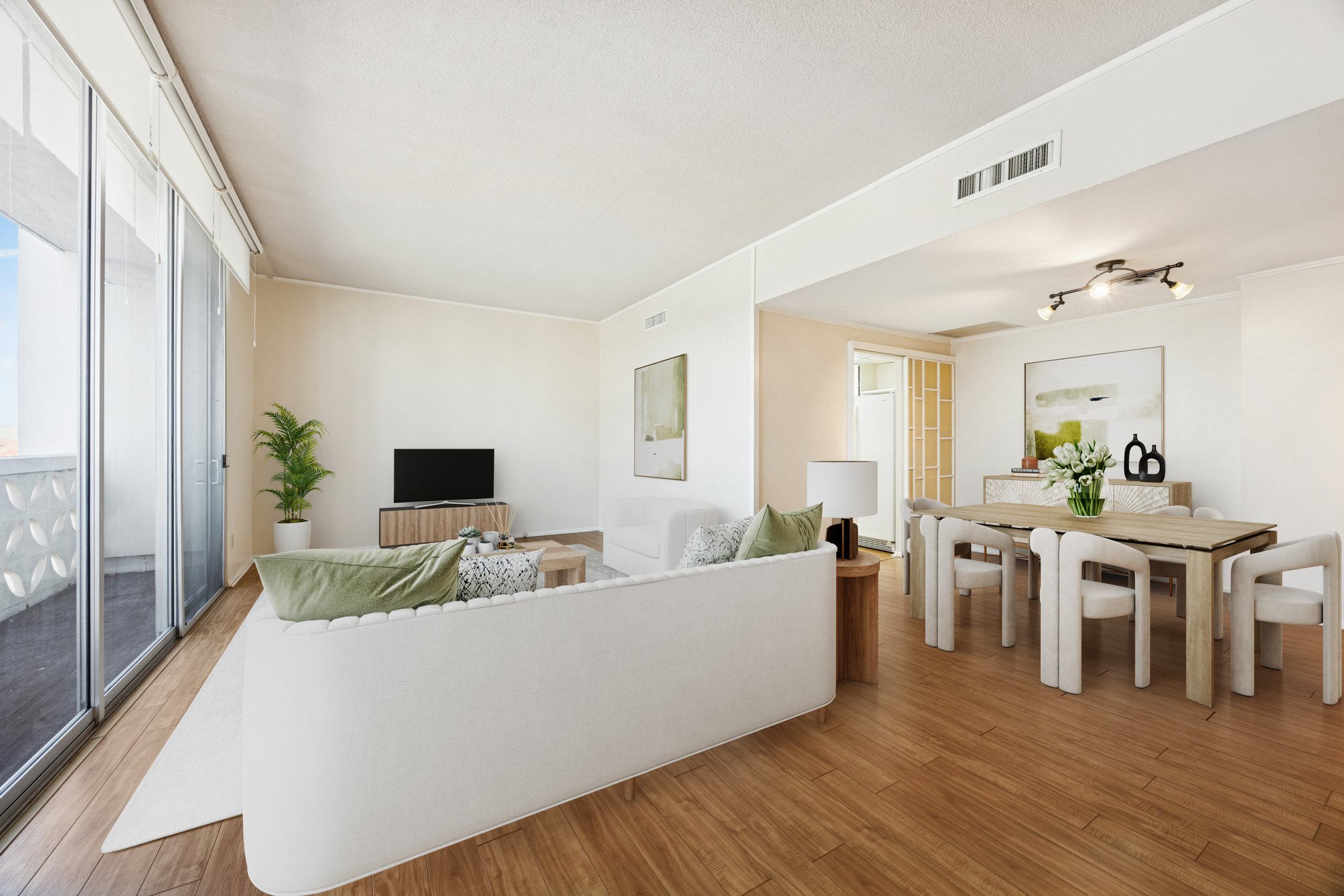 a living room with furniture a wooden floor and a flat screen tv