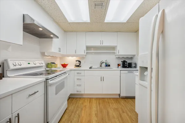 a kitchen with white cabinets and white appliances
