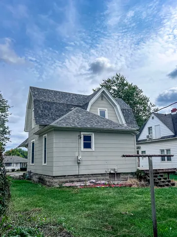 a front view of a house with a garden and yard