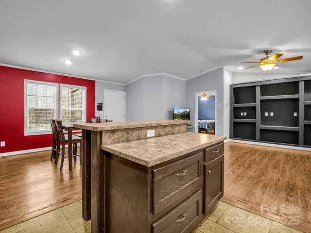 a dining hall with stainless steel appliances granite countertop a dining table and chairs