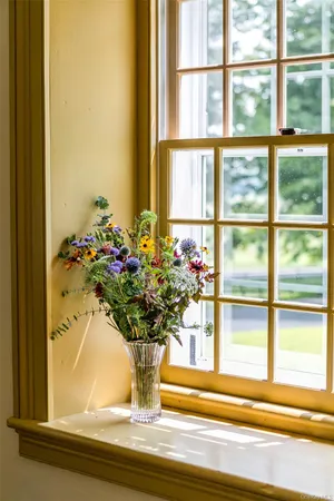 a vase of flowers sitting on a window sill