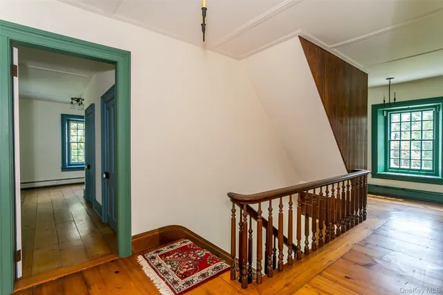 a view of hallway with stairs and wooden floor