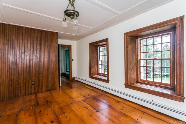 a view of an empty room with window and cabinet