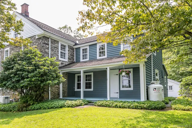a front view of house with yard and trees around