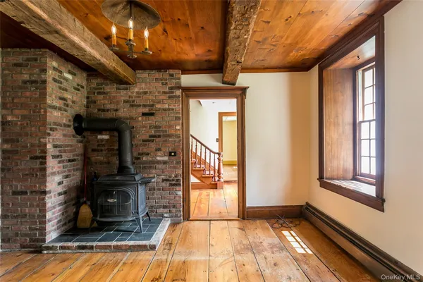 a view of a hallway with wooden floor and a fireplace