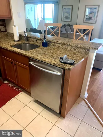 a kitchen with granite countertop a sink a stove and cabinets