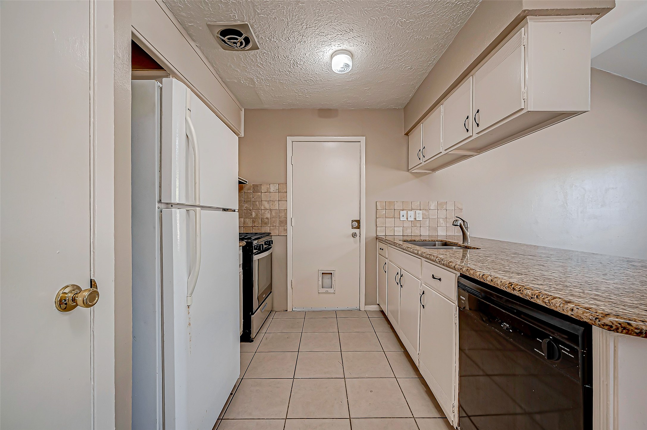 7027 Inkberry Drive Houston, TX 77092 - Photo 12 of 37 a kitchen with a refrigerator and a sink