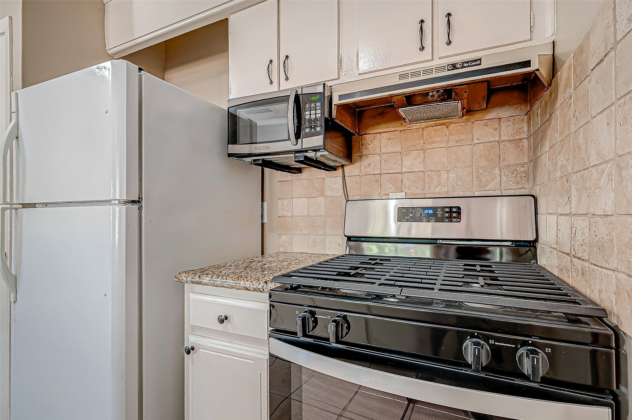 7027 Inkberry Drive Houston, TX 77092 - Photo 15 of 37 a kitchen with stainless steel appliances granite countertop a stove and a refrigerator