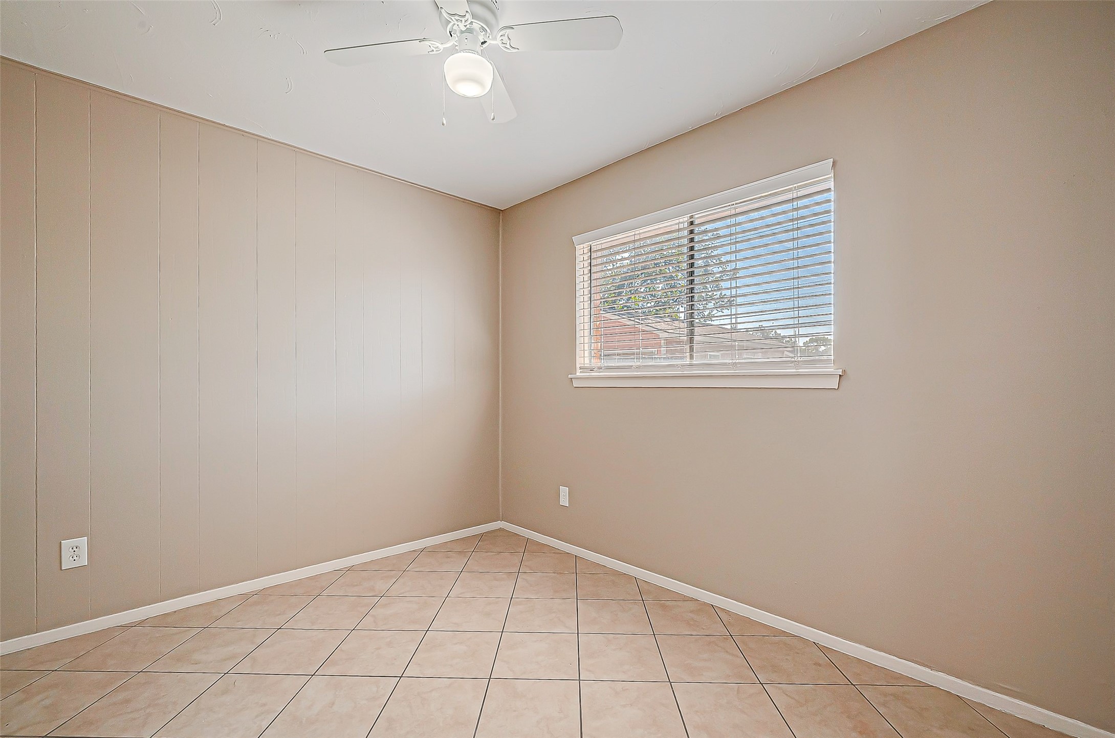 7027 Inkberry Drive Houston, TX 77092 - Photo 20 of 37 an empty room with a chandelier fan and windows
