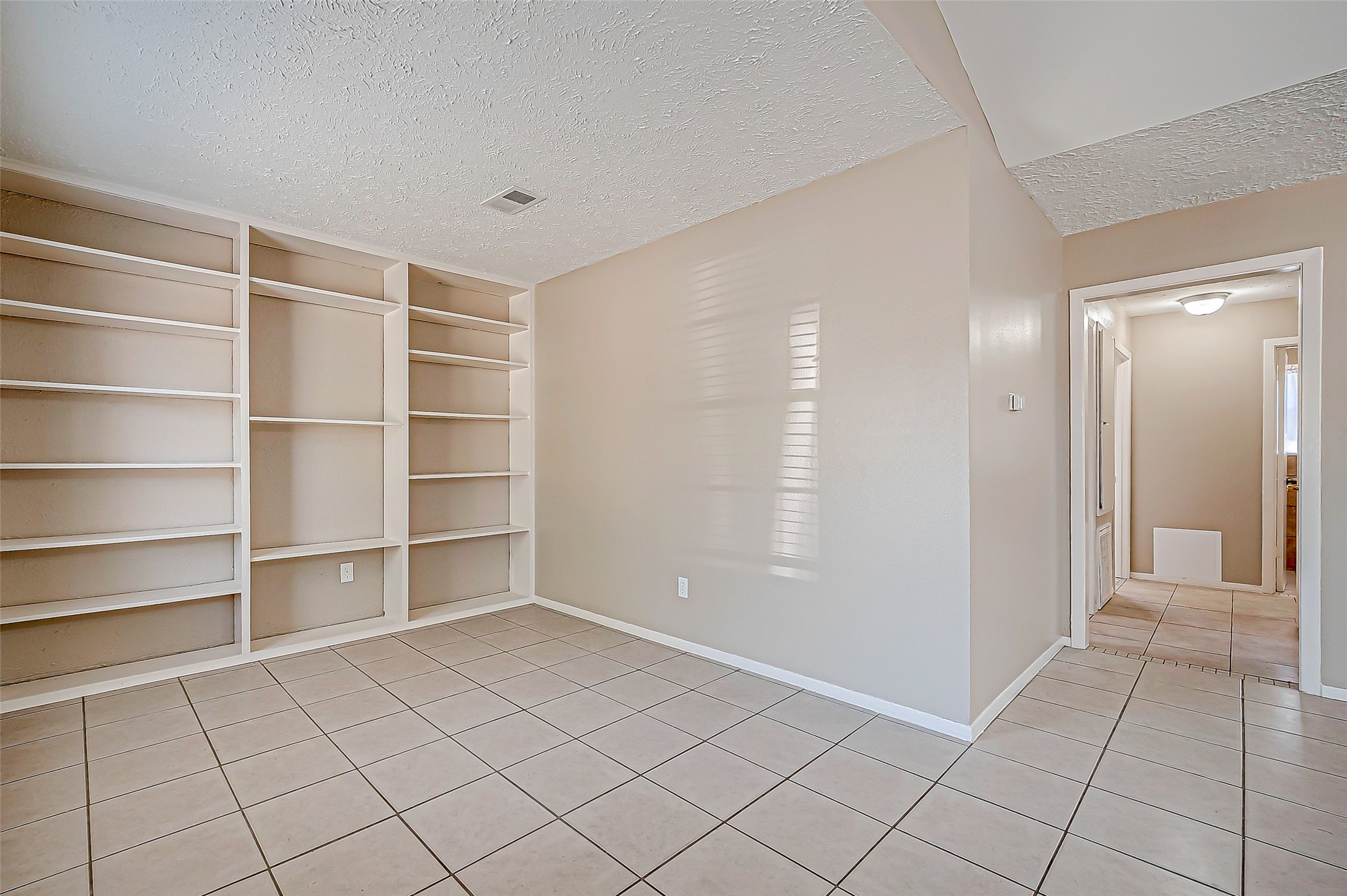 7027 Inkberry Drive Houston, TX 77092 - Photo 6 of 37 a view of an empty room with cabinet and window
