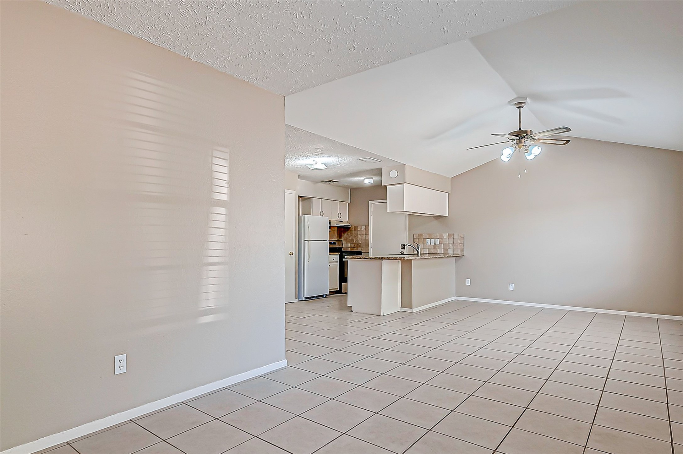 7027 Inkberry Drive Houston, TX 77092 - Photo 7 of 37 a view of a kitchen with a sink and a refrigerator