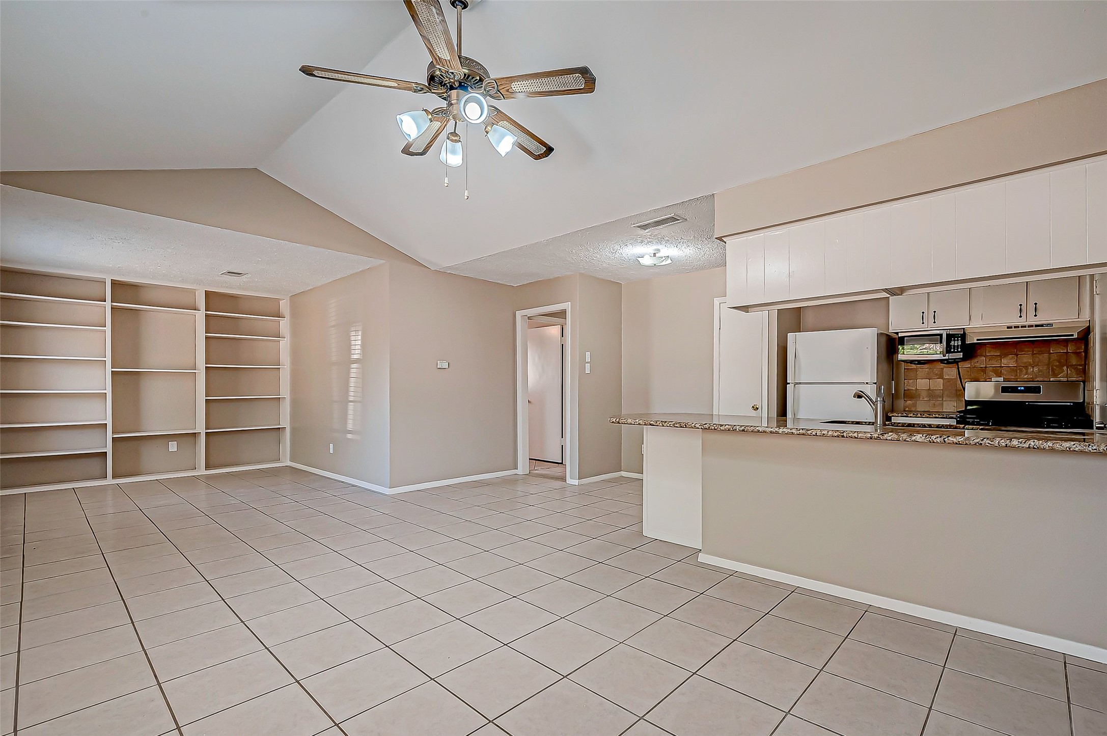 7027 Inkberry Drive Houston, TX 77092 - Photo 10 of 37 a view of a livingroom with furniture and a ceiling fan