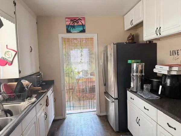 a kitchen with stainless steel appliances granite countertop a refrigerator and a sink