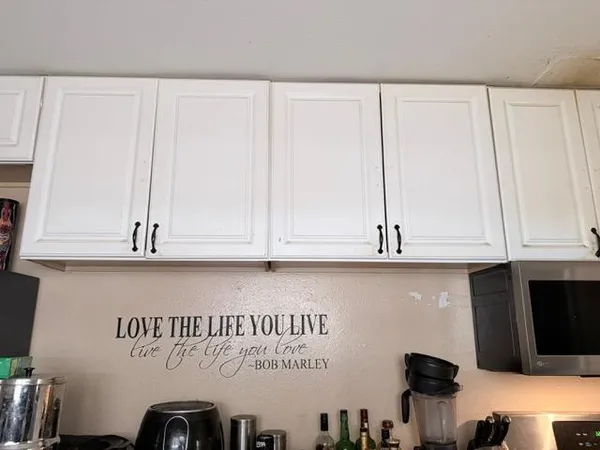 a view of kitchen with granite countertop white cabinets and a wooden floor