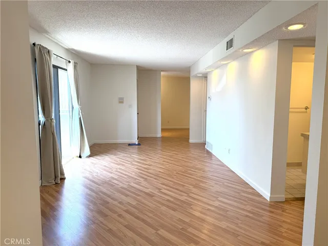 a view of empty room with wooden floor and fireplace