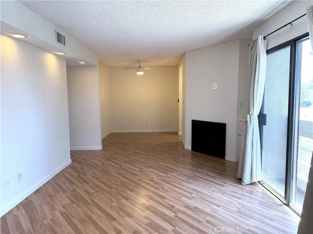 an empty room with wooden floor and a bathroom